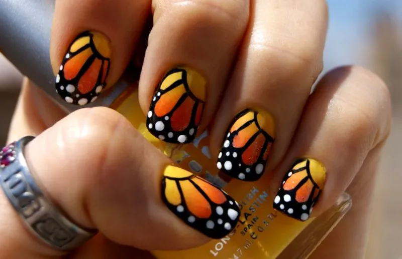 Uñas naranjas mariposa con motivo animal