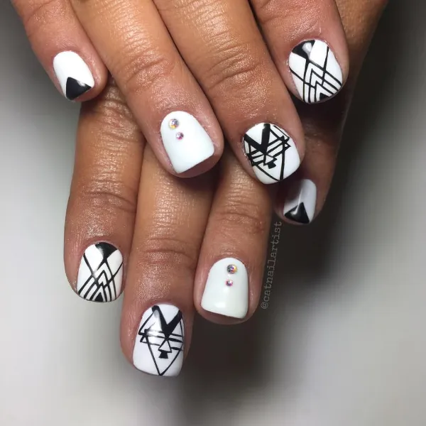 Uñas geométricas en blanco y negro con formas variadas